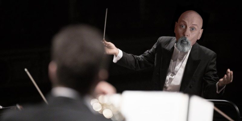 Jonathan Wilcock posing as an orchestral conductor